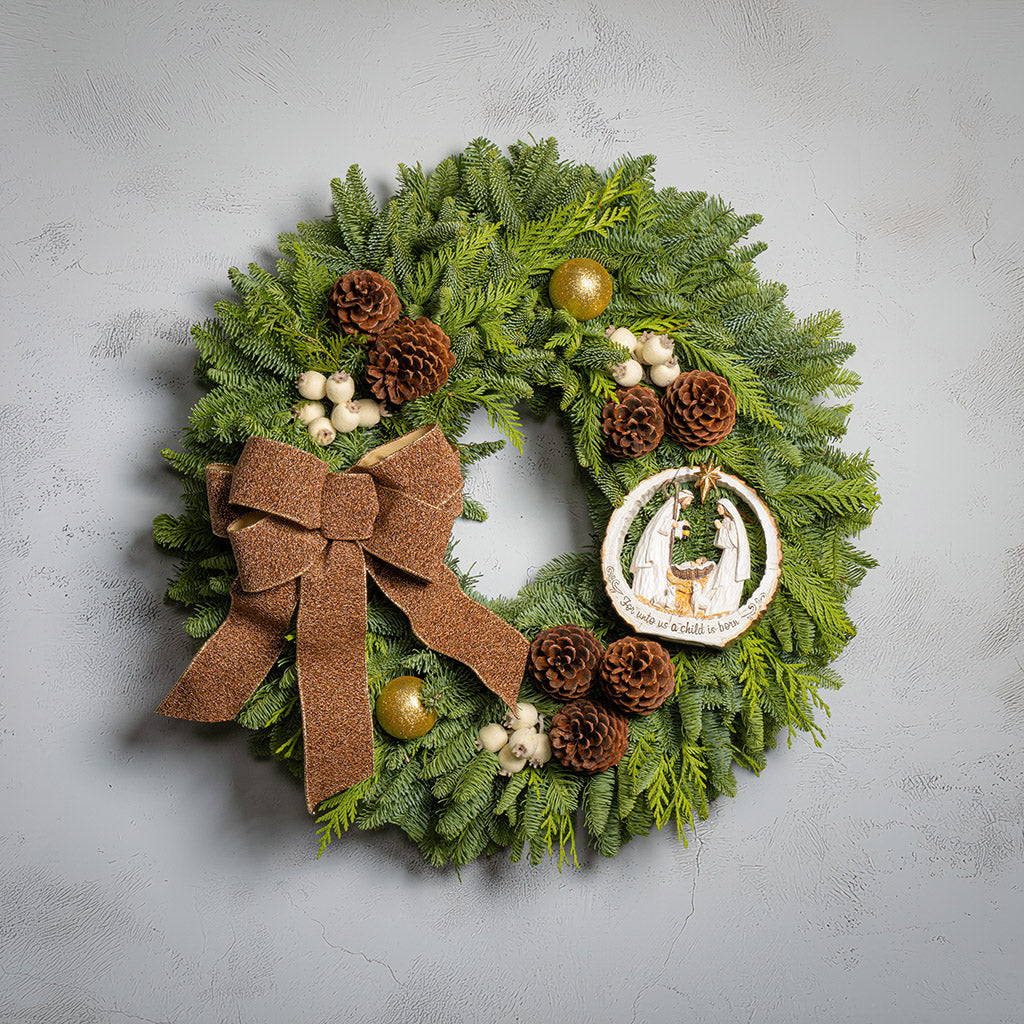 Decorative Christmas wreath with greenery, pinecones, and a brown bow on a gray background