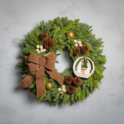 Decorative Christmas wreath with greenery, pinecones, and a brown bow on a gray background