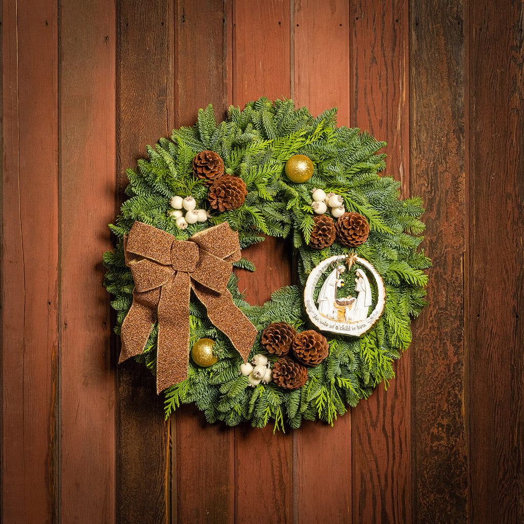 Christmas wreath with a brown bow and decorative elements on a wooden door