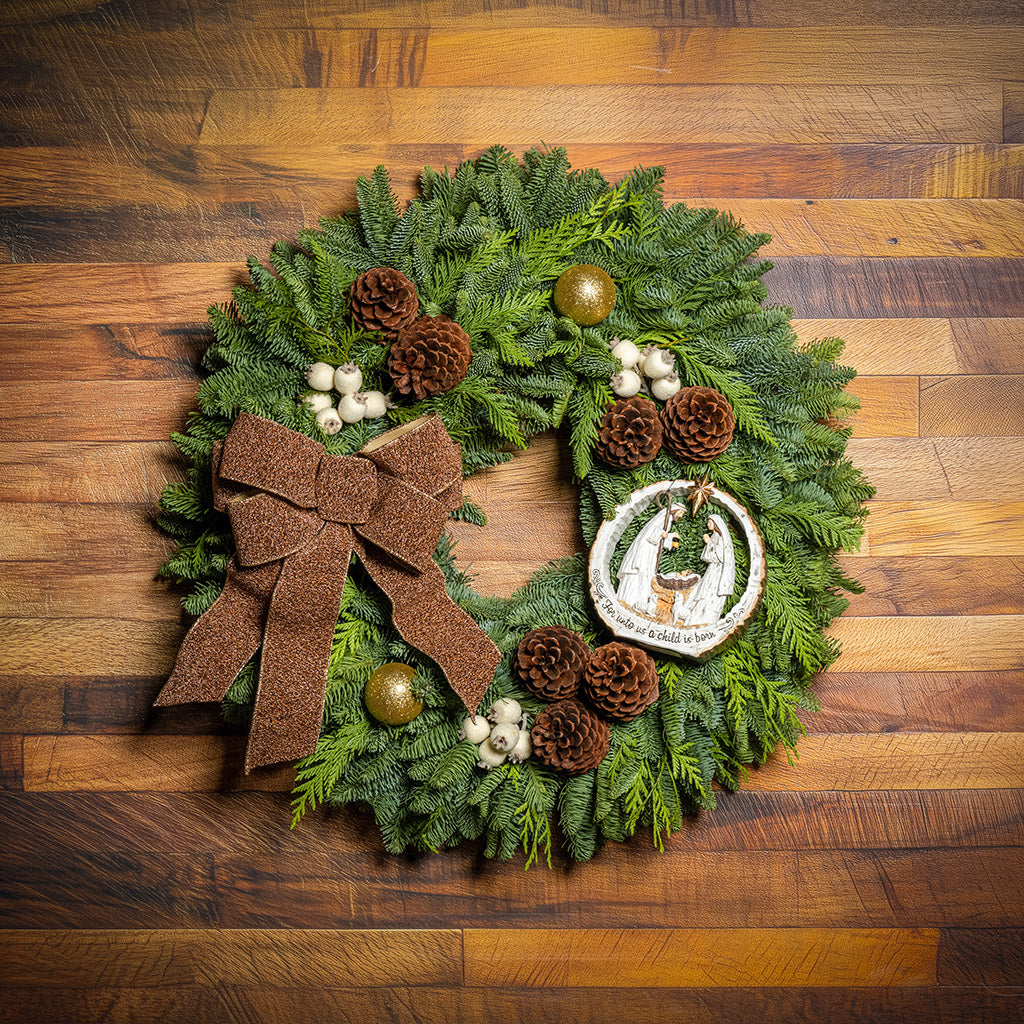 Decorative Christmas wreath with a brown bow and pinecones on a wooden background