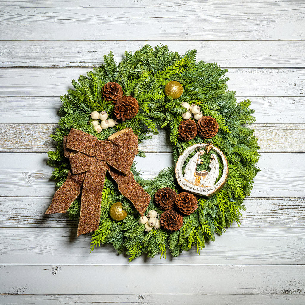 Decorative Christmas wreath with pine cones, berries, and a brown bow on a wooden background