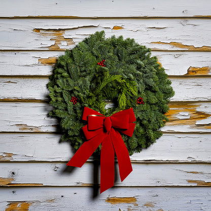 22" Christmas wreath of fir and cedar with three red berry clusters and a gold-backed red velveteen bow