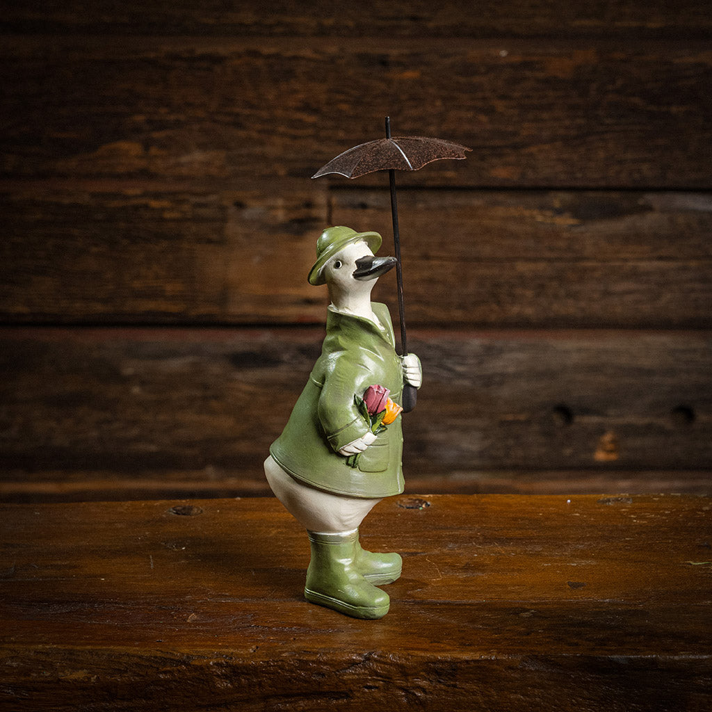 White duck in green rain gear holding a brown umbrella