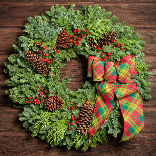 red decorations with red and green plaid bow on evergreen wreath