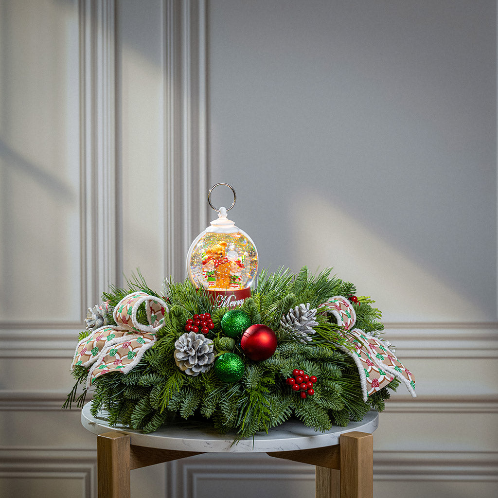 noble fir, cedar, and pine with green-and-red glittery ball ornaments, frosted pinecones, faux red berries, pink-and-green gumdrop-themed bow tucks, and a red holiday-themed water globe