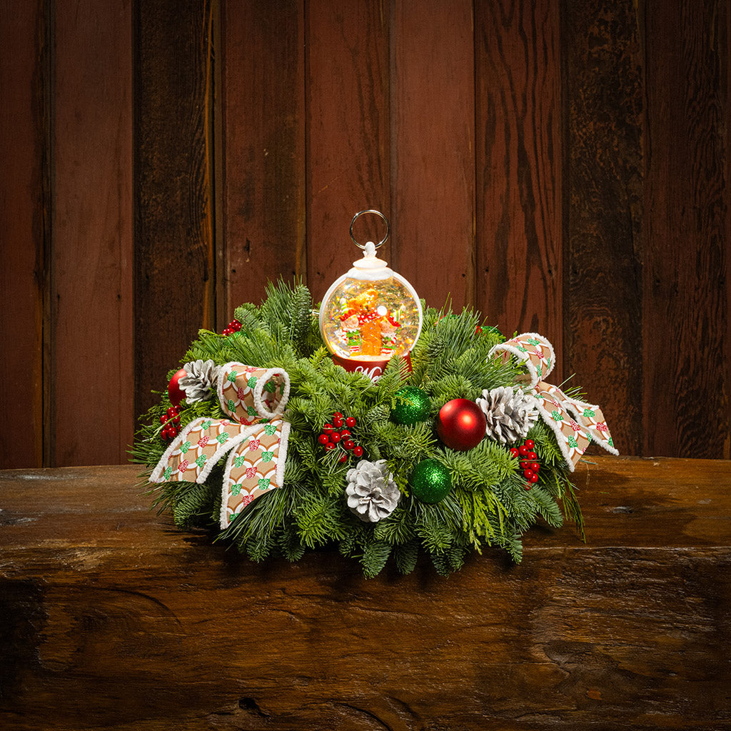 noble fir, cedar, and pine with green-and-red glittery ball ornaments, frosted pinecones, faux red berries, pink-and-green gumdrop-themed bow tucks, and a red holiday-themed water globe