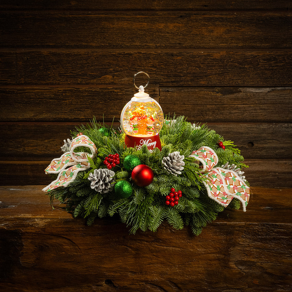 noble fir, cedar, and pine with green-and-red glittery ball ornaments, frosted pinecones, faux red berries, pink-and-green gumdrop-themed bow tucks, and a red holiday-themed water globe