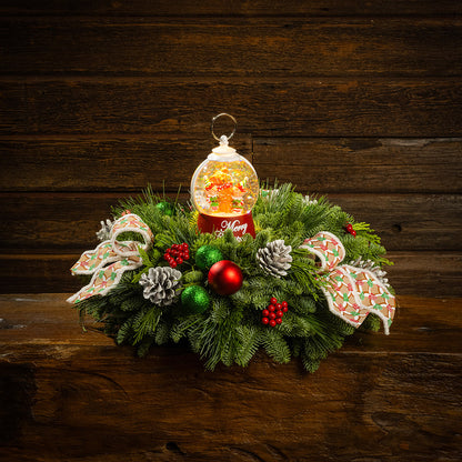 noble fir, cedar, and pine with green-and-red glittery ball ornaments, frosted pinecones, faux red berries, pink-and-green gumdrop-themed bow tucks, and a red holiday-themed water globe