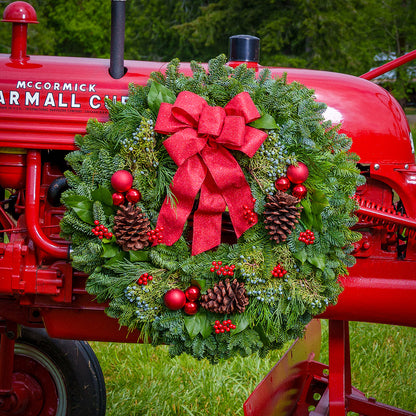 Red balls and berries with a red sparkle bow on evergreen wreath