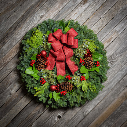 Red balls and berries with a red sparkle bow on evergreen wreath