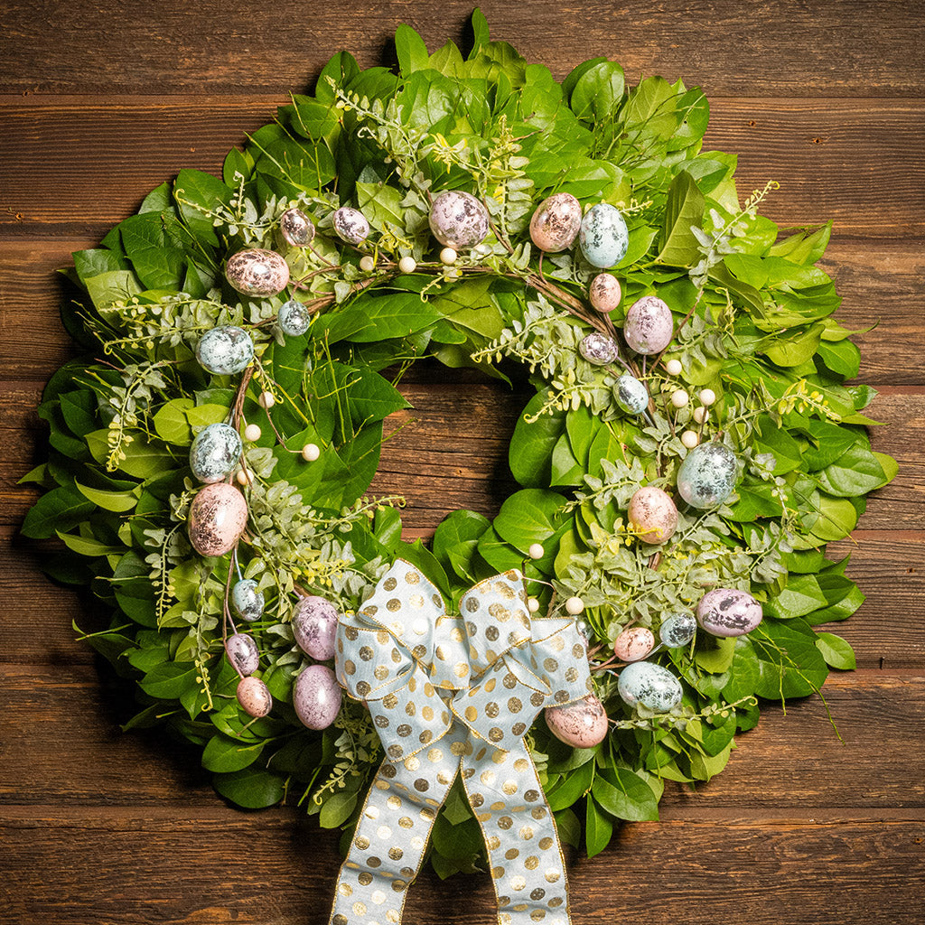 Fresh salal and sweet huckleberry with metallic pastel eggs and faux fern leaves with a light-blue polka dot bow