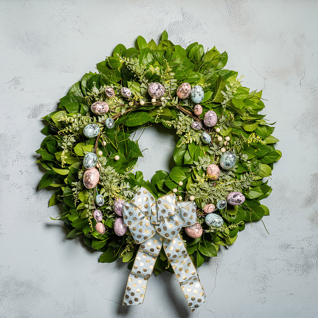 Fresh salal and sweet huckleberry with metallic pastel eggs and faux fern leaves with a light-blue polka dot bow