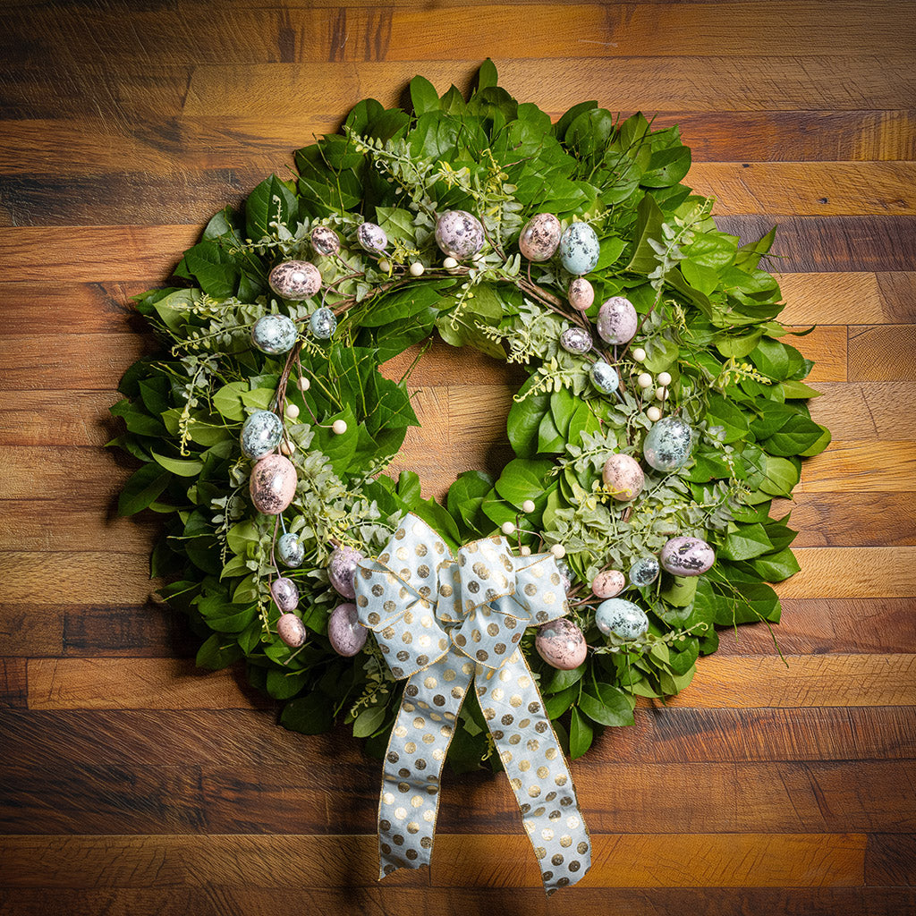 Fresh salal and sweet huckleberry with metallic pastel eggs and faux fern leaves with a light-blue polka dot bow