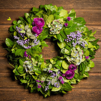 Fresh salal and sweet huckleberry with faux purple ranunculus flowers, purple statice, faux purple hydrangeas, and faux light-purple berries