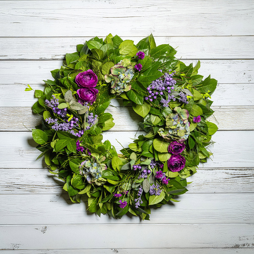 Fresh salal and sweet huckleberry with faux purple ranunculus flowers, purple statice, faux purple hydrangeas, and faux light-purple berries