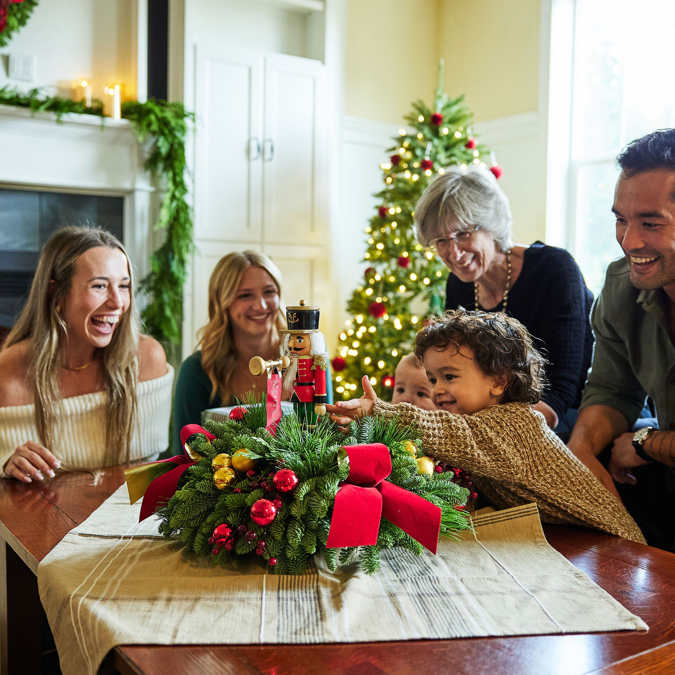 Family gathered around a Christmas tree with a decorated table in the foreground
