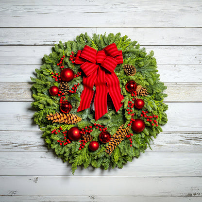 Christmas wreath with red bow and decorations on a wooden background