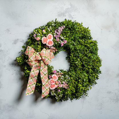 Fresh boxwood with faux lavender, peach roses, lilac, and small faux white baby’s breath flowers with a coral, cream, and green plaid bow