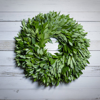 Green leafy wreath on a white wooden background