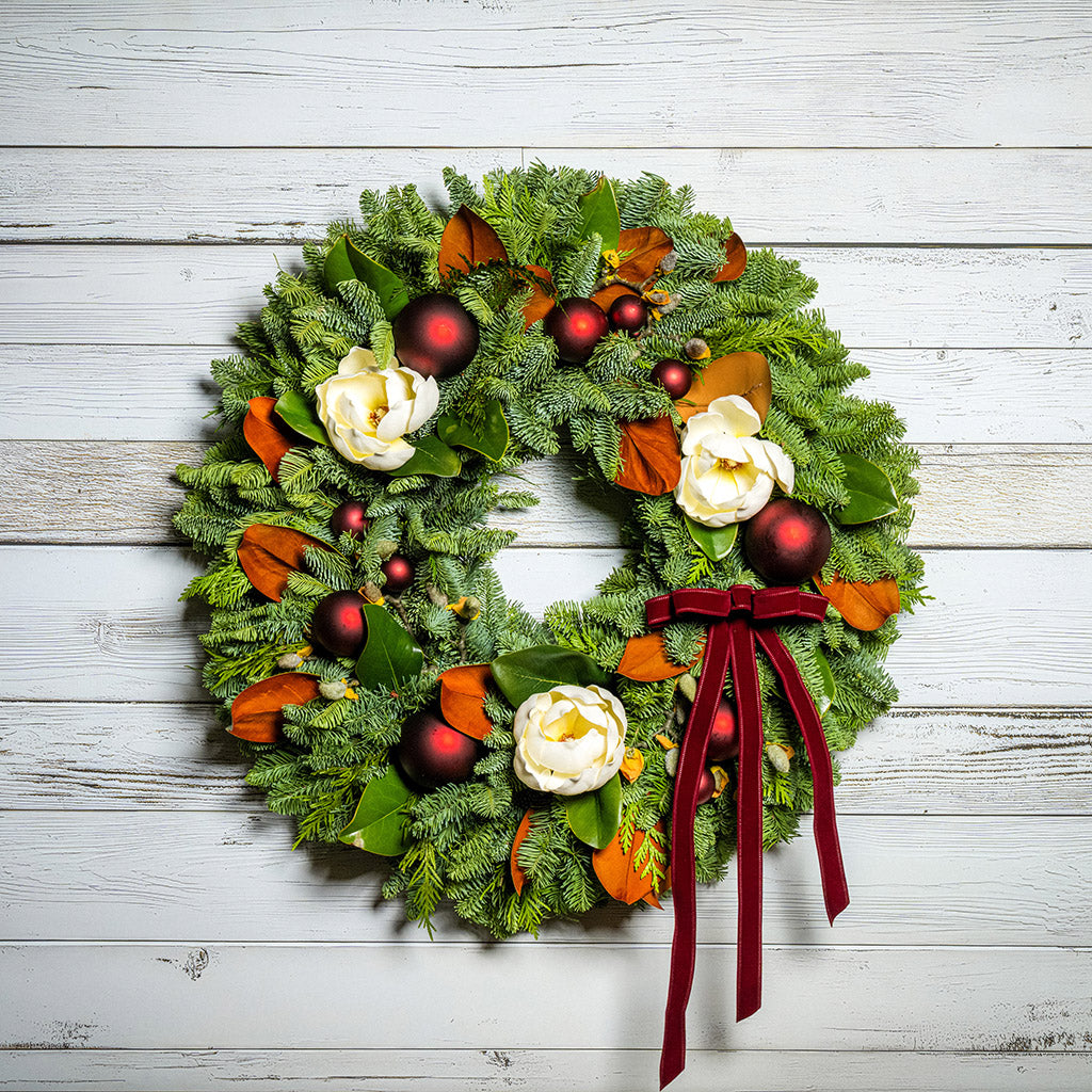 Decorative Christmas wreath with red and gold ornaments on a wooden background