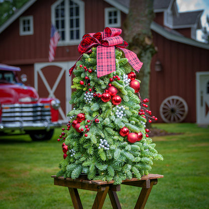 Assembled tree of noble fir,red ornaments, silver berries, red berry branch and a red and black tartan bow