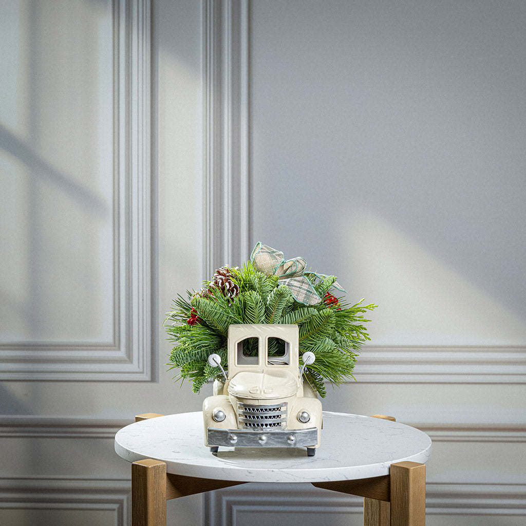 noble fir, cedar, and pine with faux red berries, frosted pinecones, and a sage plaid bow in a cream metal truck container