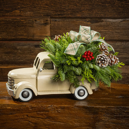 noble fir, cedar, and pine with faux red berries, frosted pinecones, and a sage plaid bow in a cream metal truck container