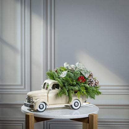 noble fir, cedar, and pine with faux red berries, frosted pinecones, and a sage plaid bow in a cream metal truck container