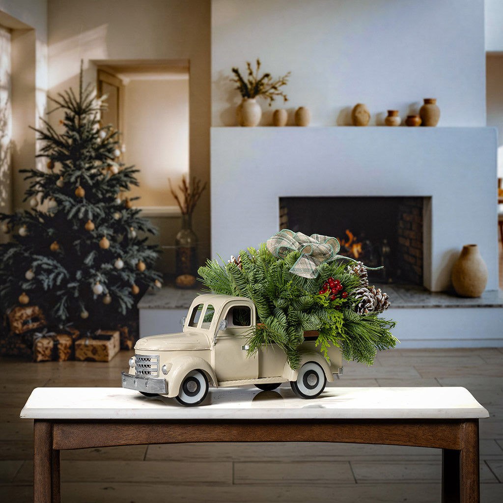 noble fir, cedar, and pine with faux red berries, frosted pinecones, and a sage plaid bow in a cream metal truck container