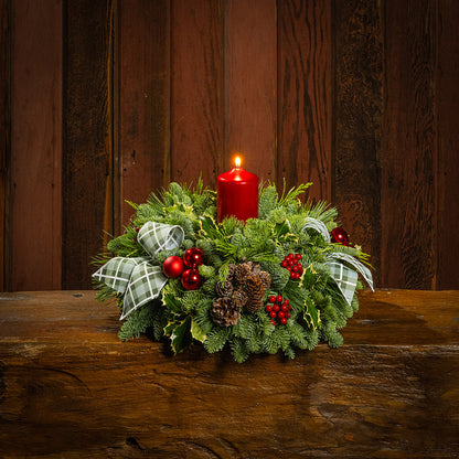 noble fir, cedar, pine, and variegated holly with red ball ornaments, faux red berries, natural pinecones, green-and-white plaid bow tucks, and a red metallic pillar candle