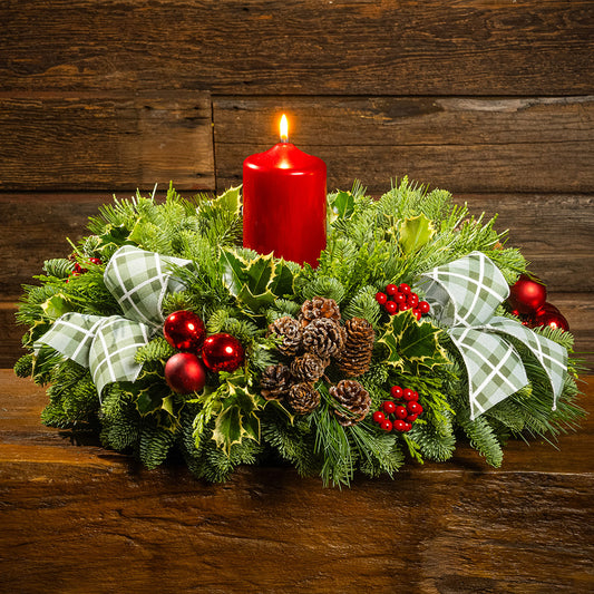 noble fir, cedar, pine, and variegated holly with red ball ornaments, faux red berries, natural pinecones, green-and-white plaid bow tucks, and a red metallic pillar candle
