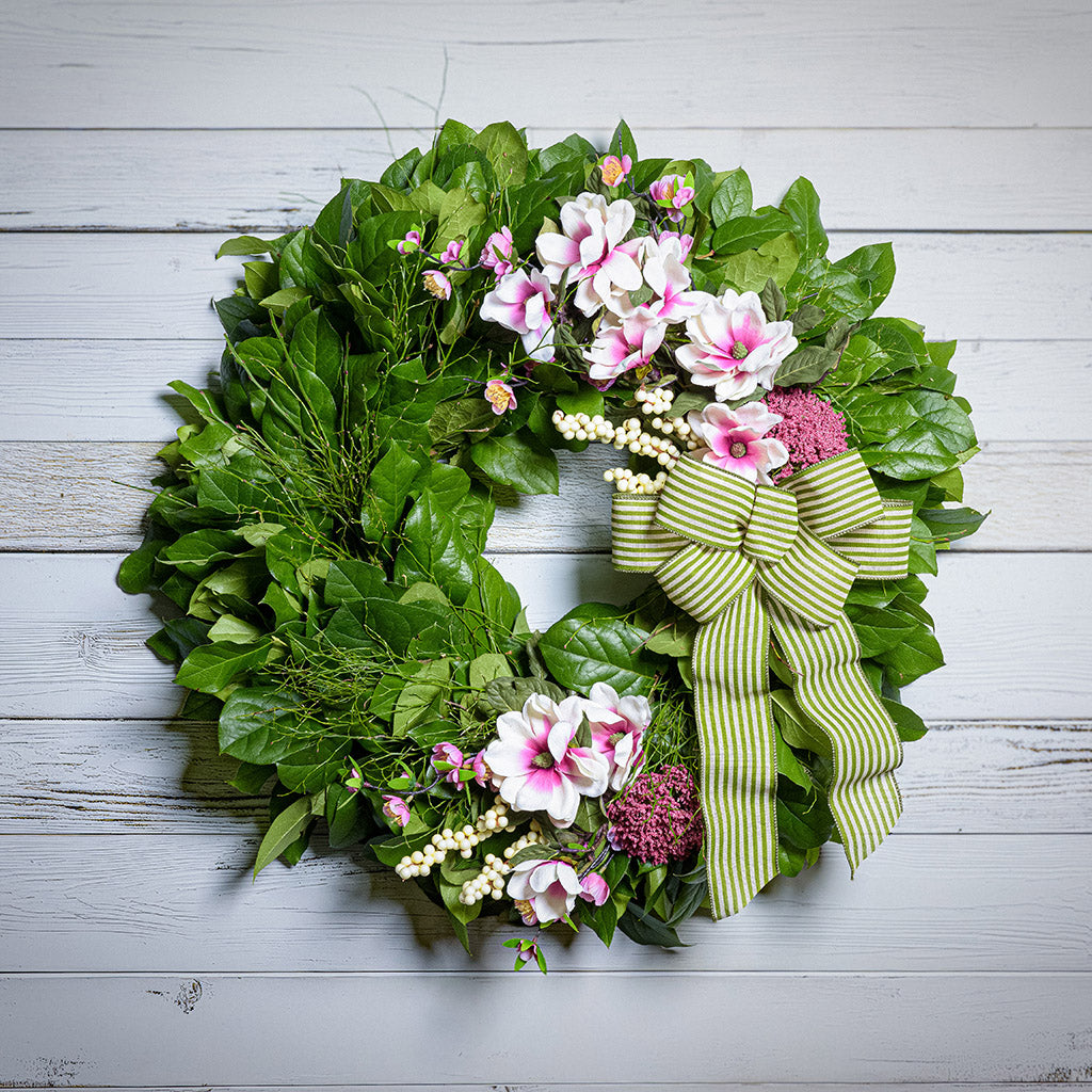 Floral wreath with green bow on a wooden background