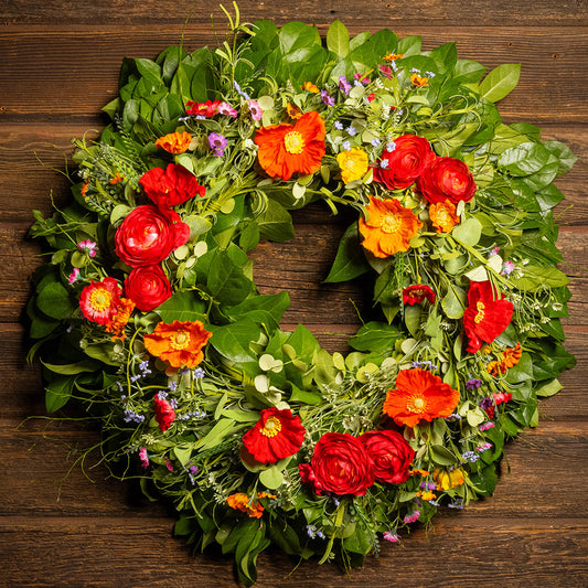 Fresh salal and sweet huckleberry with mixed colors of faux poppy flowers and faux red ranunculus flowers