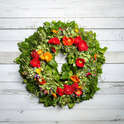 Fresh salal and sweet huckleberry with mixed colors of faux poppy flowers and faux red ranunculus flowers