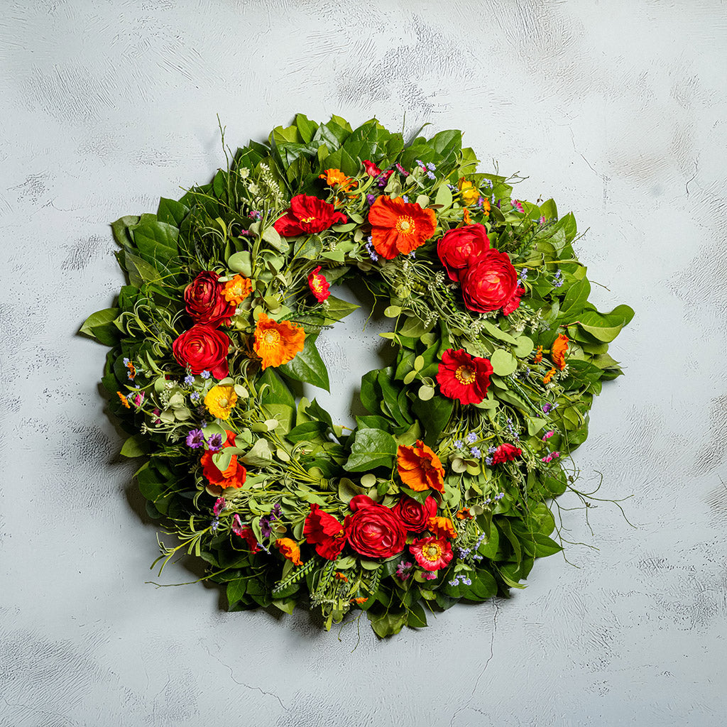 Fresh salal and sweet huckleberry with mixed colors of faux poppy flowers and faux red ranunculus flowers