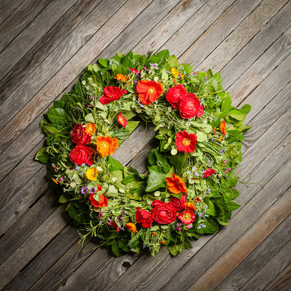 Fresh salal and sweet huckleberry with mixed colors of faux poppy flowers and faux red ranunculus flowers