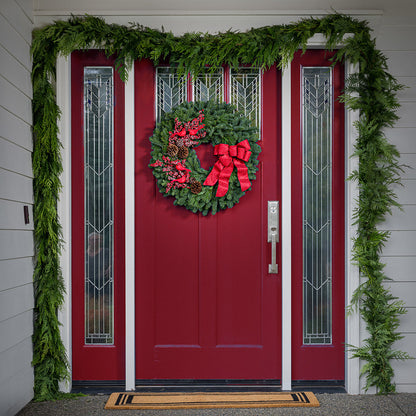 red cardinals with red berries and red sparkle bow on evergreen wreath