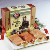 Unpackaged box of smoked salmon, crackers, and fruit on a plate.