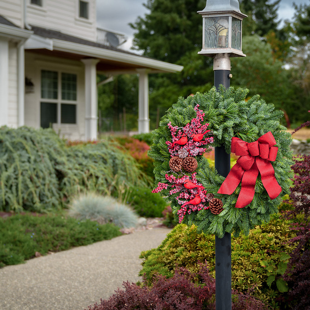 red cardinals with red berries and red sparkle bow on evergreen wreath