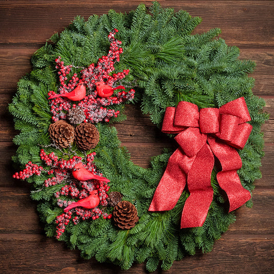 red cardinals with red berries and red sparkle bow on evergreen wreath