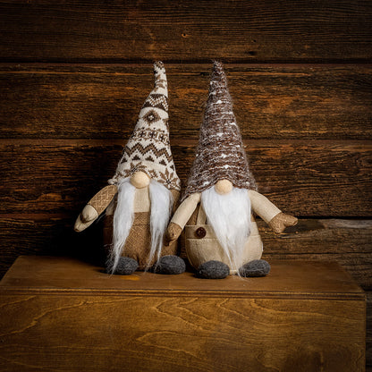 14” Gnomes weighted at the bottom with their noses poking out of tall brown and white pointy hats, their fuzzy white beards, and brown linen outfits sitting on a wood table with a dark wood background.