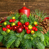 Centerpiece made of noble fir, cedar, and pine with ponderosa pine cones, Australian pine cones, red ball clusters, red and green faux berry picks, red-and-green plaid bow tucks, and a red pillar candle close up