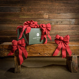 6 Brushed Linen Red bows shown with a green shipping box sitting on a wood bench with a dark wood background.