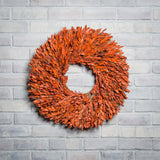 22” natural wreath is handmade with orange myrtle on a white brick background. 