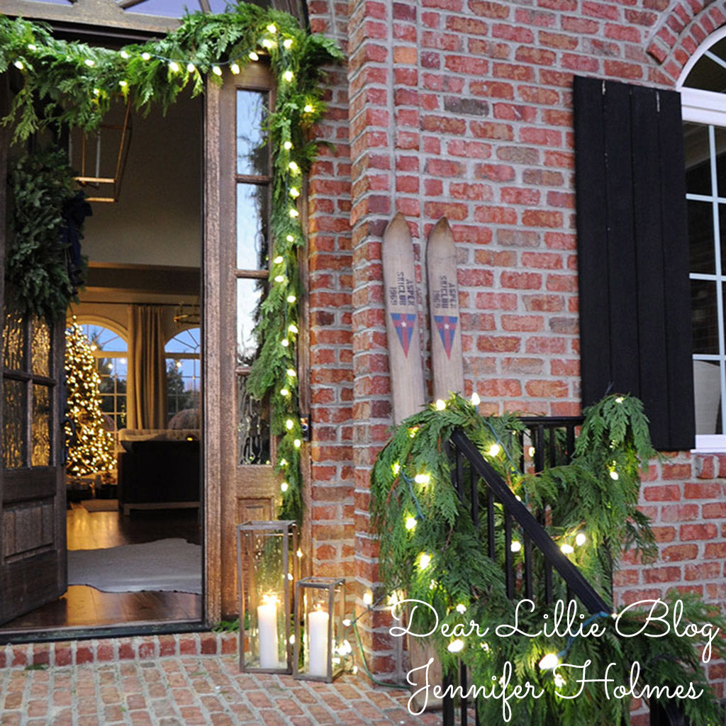 Western red cedar garland with lights hung around a front door and down the railing of the front steps.