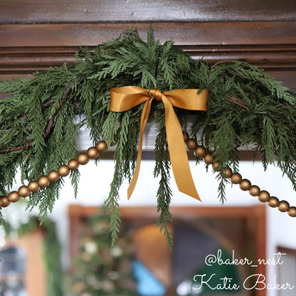 Western red cedar garland accented with beads and gold bow.