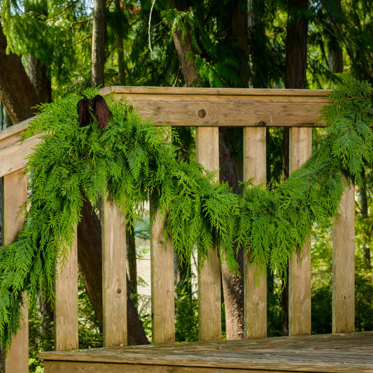 Western red cedar garland hanging from banister with chestnut garland tie