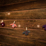 10-foot strand of white lights and sweater ornaments hanging from mini wood clothespins with a dark wooden background.