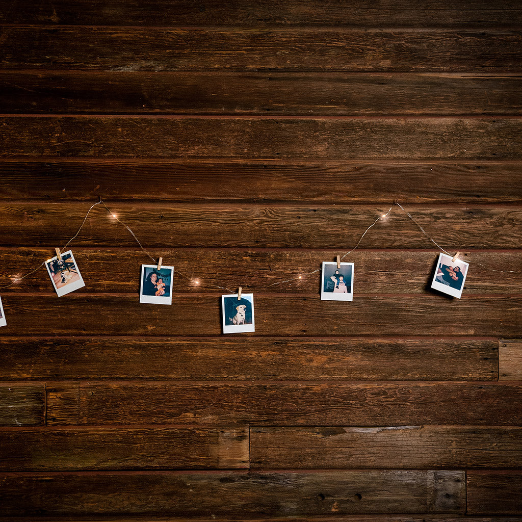 10-foot strand of white lights and pictures hanging from mini wood clothespins with a dark wooden background.