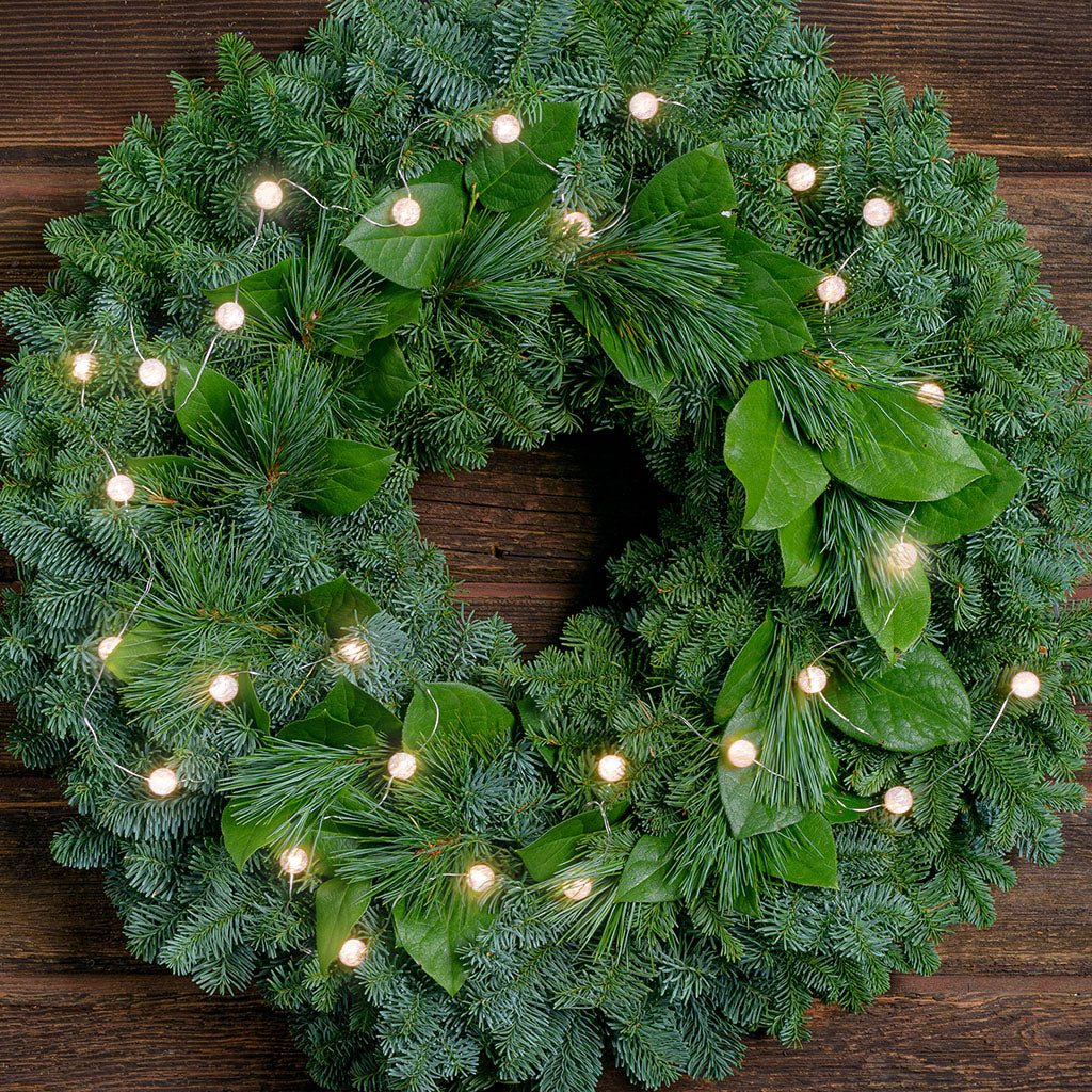 White, globe shaped, cracked glass effect battery operated lights on a evergreen wreath